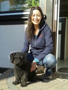 Natalie Rose steht lächelnd vor einem Gebäude.