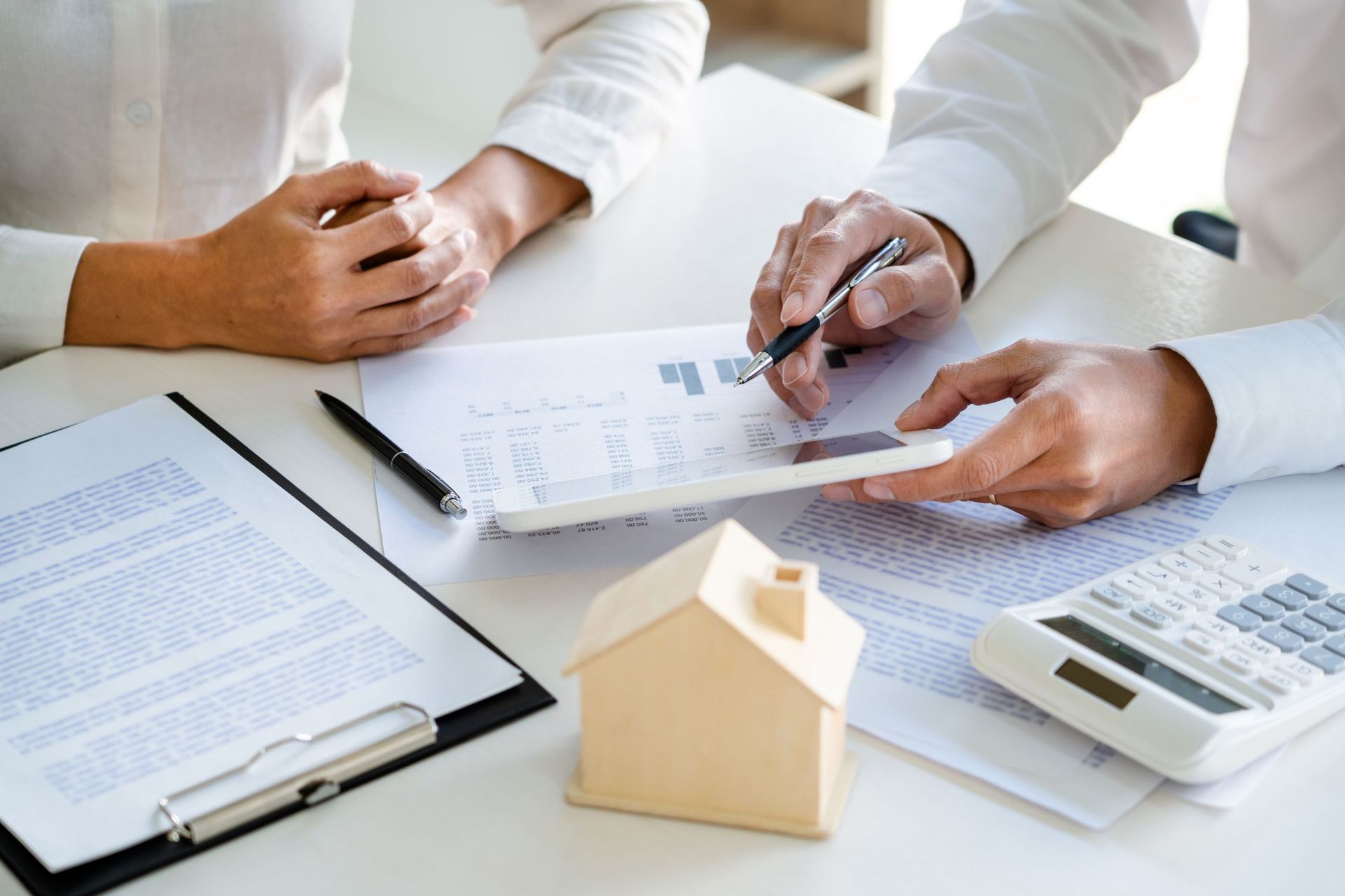 Un hombre y una mujer están sentados en una mesa mirando una tableta.