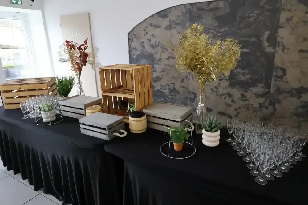 Table décorée avec des plantes, des fleurs, des caisses en bois et de la verrerie dans un espace intérieur lumineux