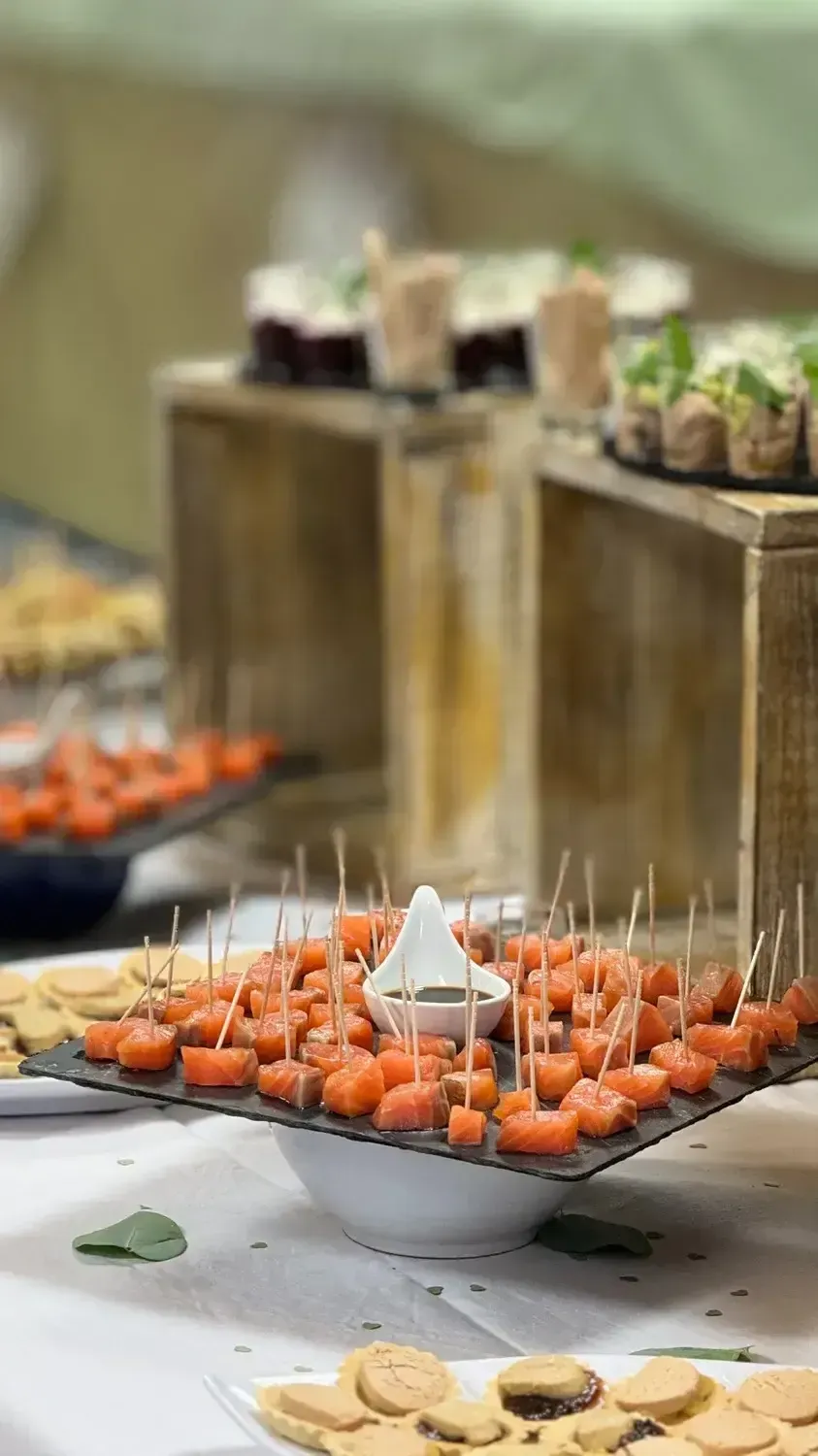 Plateau de bouchées apéritives orange piquées de cure-dents, posé sur une table de buffet.