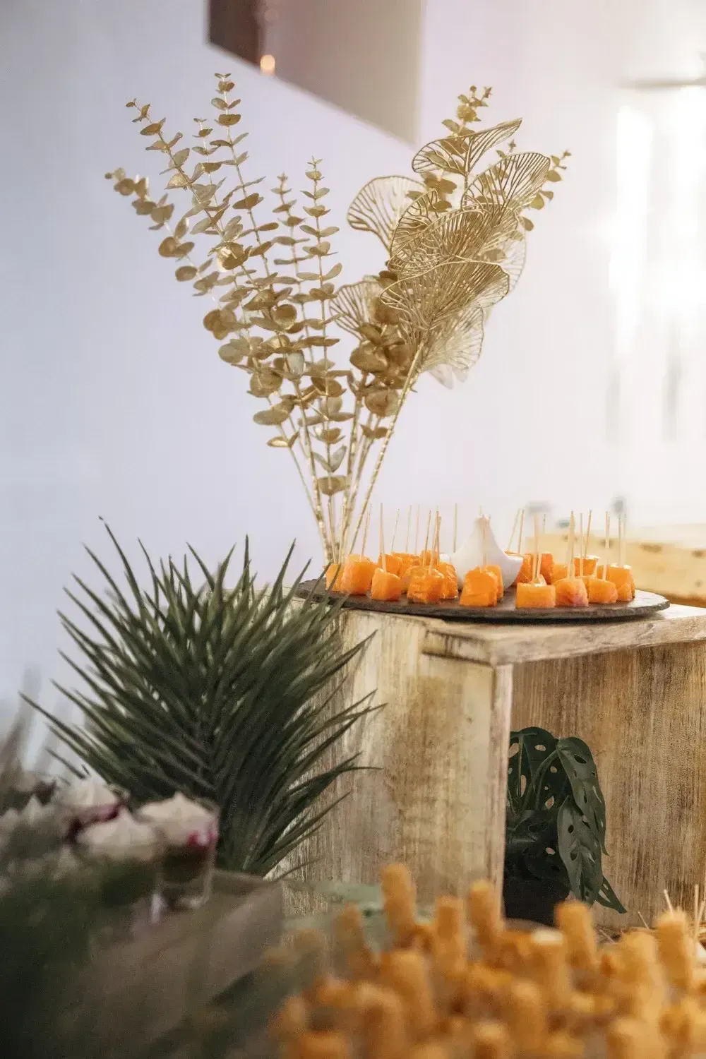 Table rustique ornée de citrouilles orange, d’herbes séchées et de bougies dans une ambiance automnale à la lumière douce