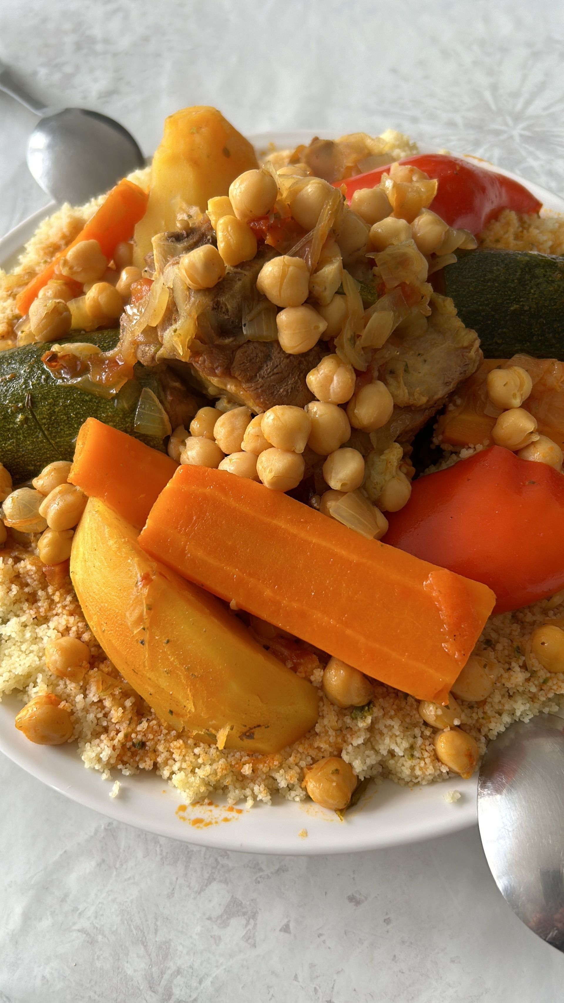 Assiette de couscous garnie de pois chiches et de légumes.