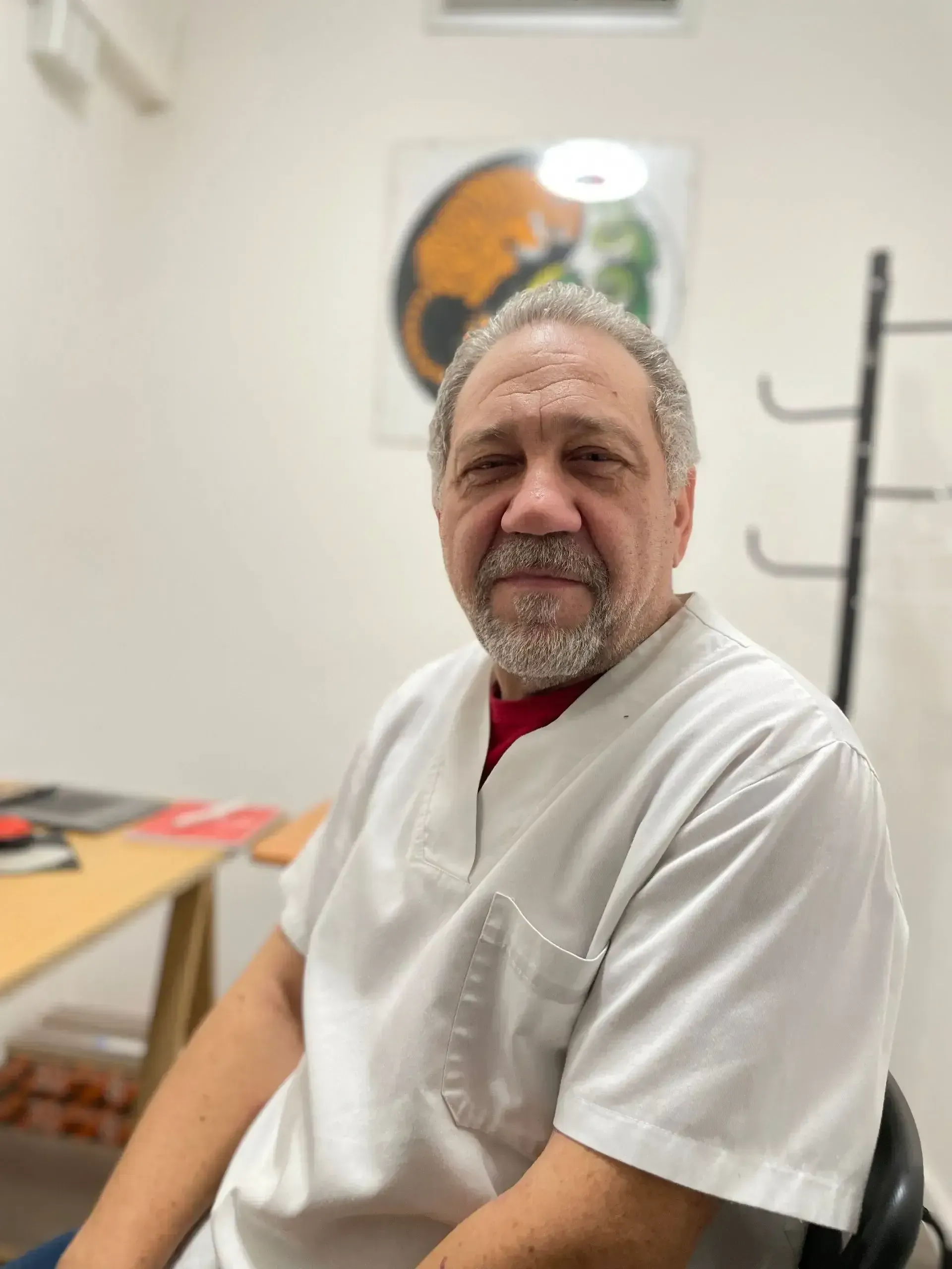 Persona recibiendo masaje de cuello de una persona con manos tatuadas, vista posterior.