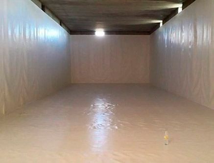 Una gran habitación vacía con paredes blancas y una luz en el techo.