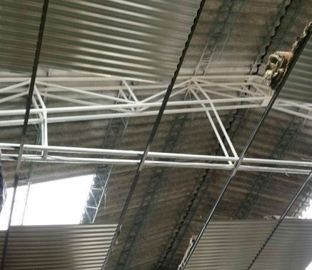 Un techo de metal con algunos cables colgando de él.
