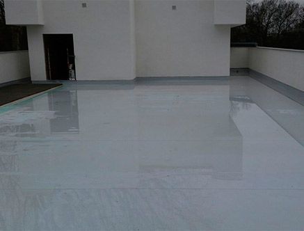 Un gran piso blanco con el reflejo de un edificio en él.