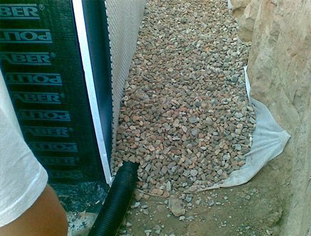 Un montón de grava junto a una pared que tiene la palabra poli escrita en ella.