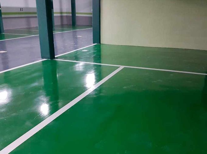 Un estacionamiento con piso verde y líneas blancas.