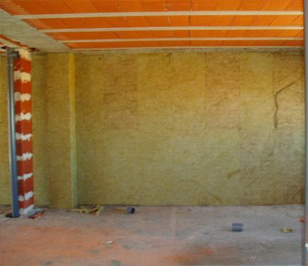 Una habitación vacía con un techo de ladrillo y una pared amarilla.