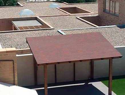 Una pérgola de madera se encuentra en el techo de un edificio.