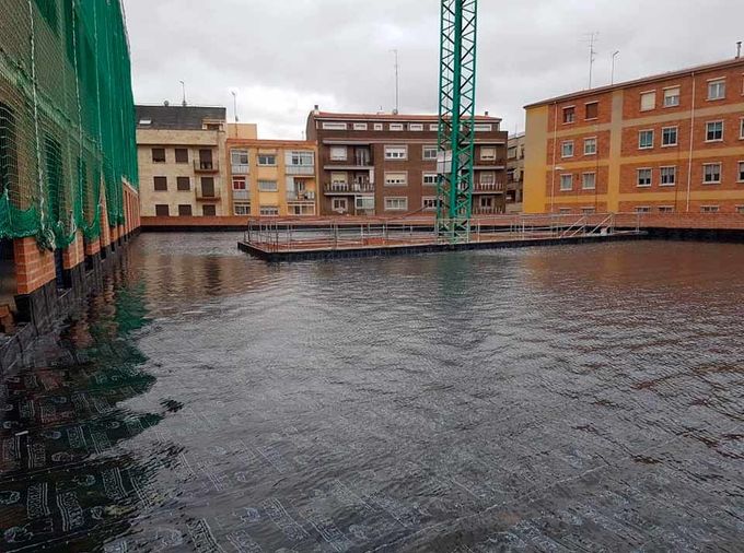 Una gran masa de agua con edificios al fondo.