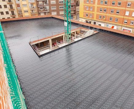 Una vista aérea de un edificio en construcción con una grúa al fondo.