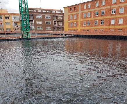 Un gran cuerpo de agua frente a un edificio de ladrillos.