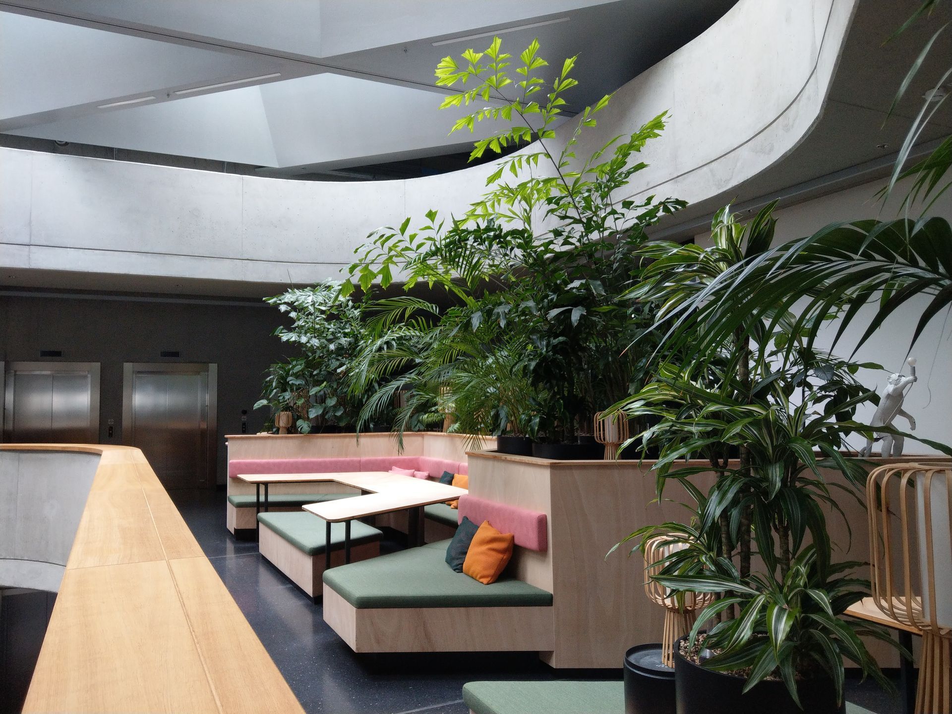 Moderne Innenarchitektur mit Pflanzen und Sitzgelegenheiten.