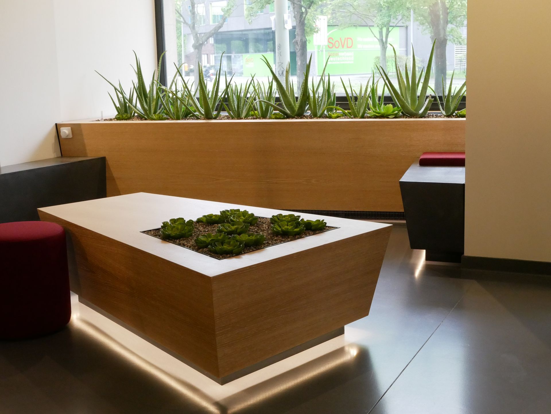 Moderne Sitzecke im Innenbereich mit einem Holztisch mit eingebauten Sukkulenten