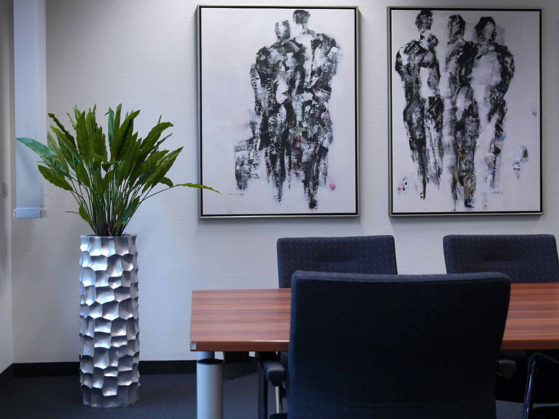 Modernes Büro mit abstrakten Kunstwerken an der Wand.