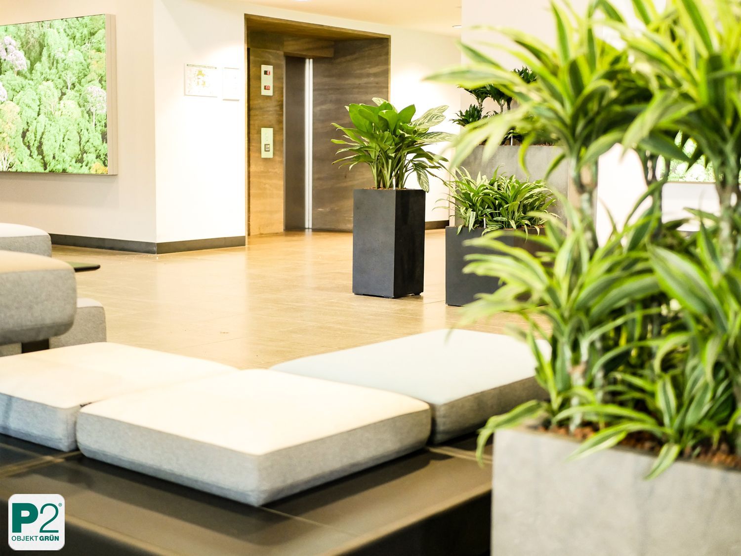 Moderne Lobby mit grünen Pflanzen und gemütlichen Sitzgelegenheiten.