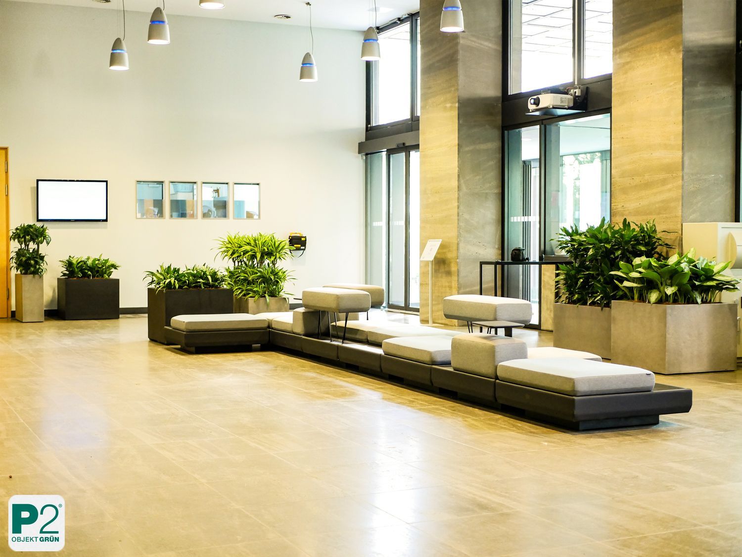 Moderne Lobby mit grünen Pflanzen und gemütlichen Sitzgelegenheiten.