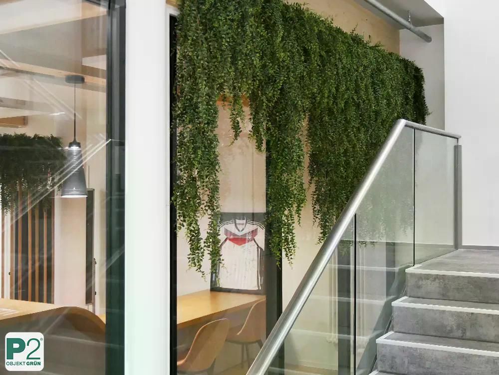 Modernes Büro mit hängenden Pflanzen und Glasgeländer