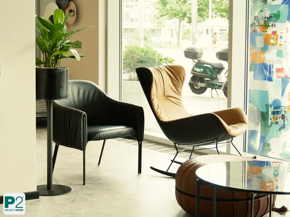 Zwei Stühle, ein schwarzer Sessel und ein brauner Schaukelstuhl.