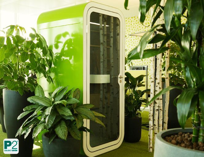 Modernes Büro mit grünen Pflanzen und einer Telefonzelle.