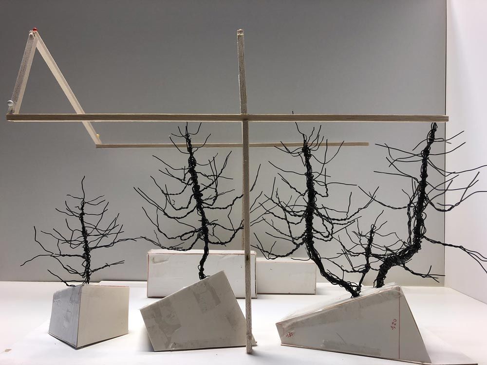 Miniaturmodell mit Drahtbäumen und weißen Sockeln, künstlerisch inszeniert.