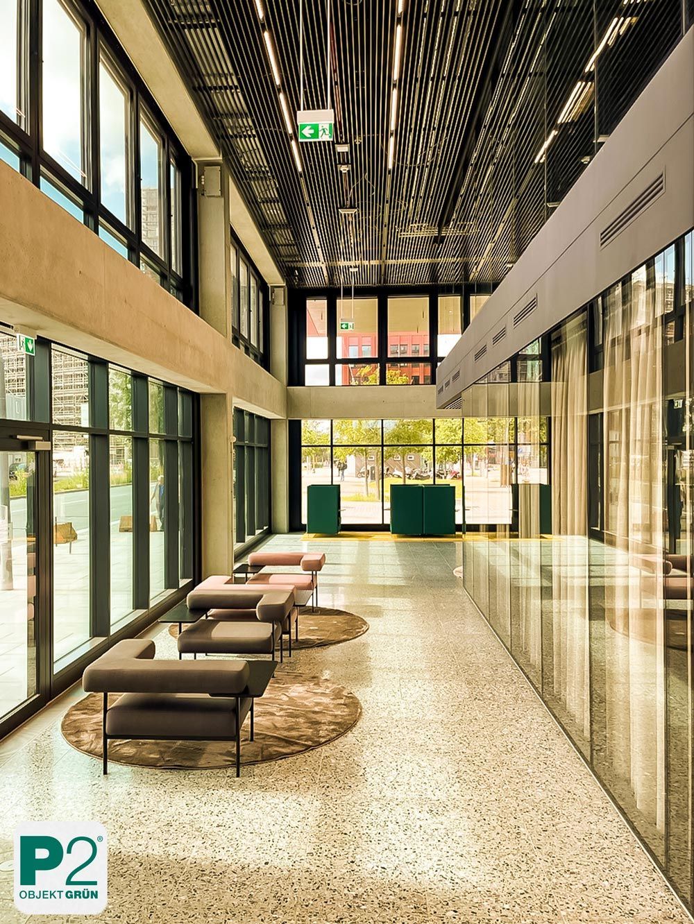 Eine moderne Lobby mit stilvollen Sitzgelegenheiten und großen Fenstern.