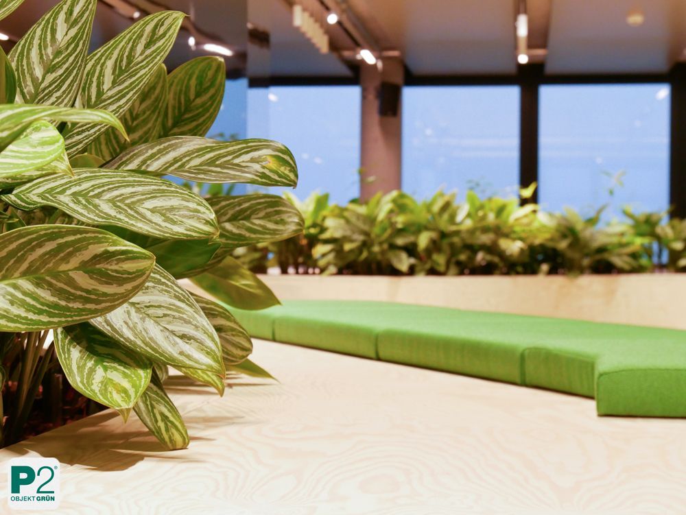 Moderne Sitzgelegenheit mit grünen Pflanzen im Hintergrund.