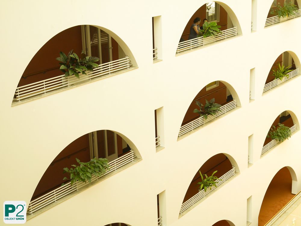 Innenhof mit Pflanzen und Balkonen in modernem Design.