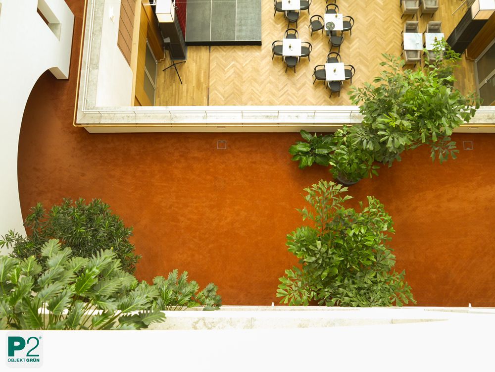 Blick auf einen modernen Innenraum mit Pflanzen und Tischen.