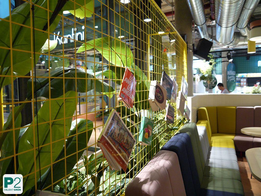 Gemütlicher Essbereich mit Pflanzen und gelber Gitterwand.