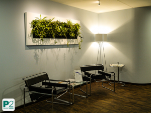 Stilvolle moderne Büroeinrichtung mit Pflanzenwand und Beleuchtung.