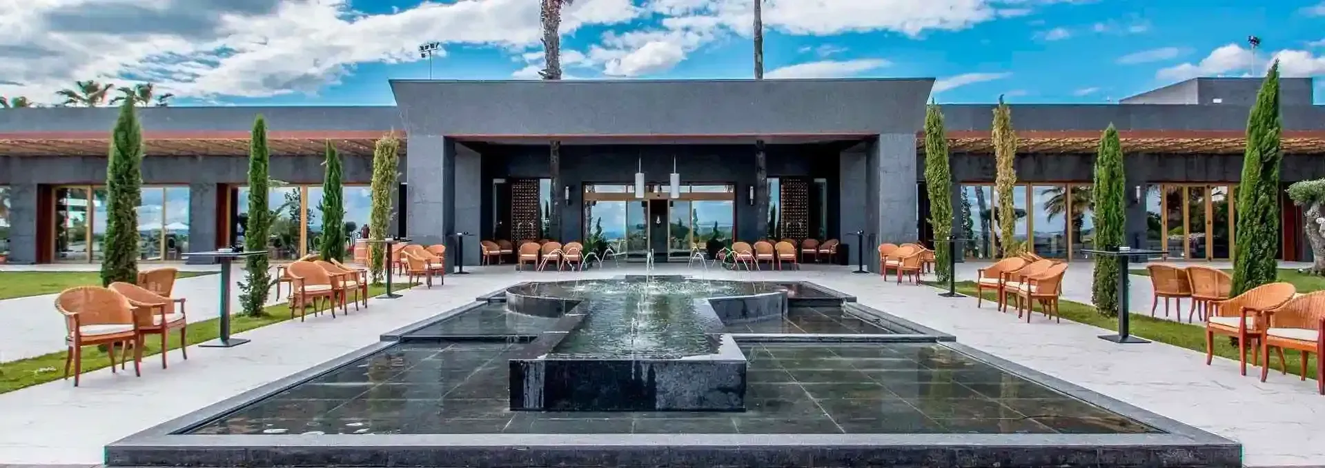 Un gran edificio con una fuente delante.