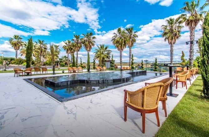 Una gran piscina rodeada de palmeras y sillas.