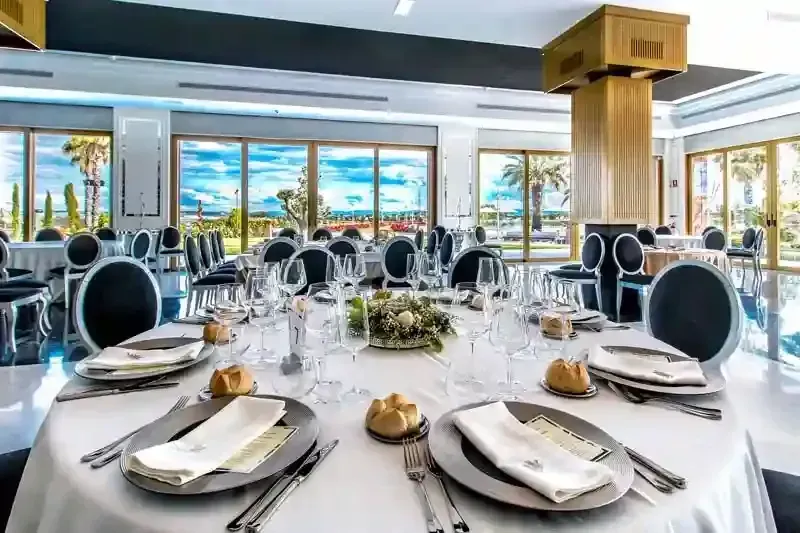 Un gran comedor con mesas y sillas preparadas para un banquete.