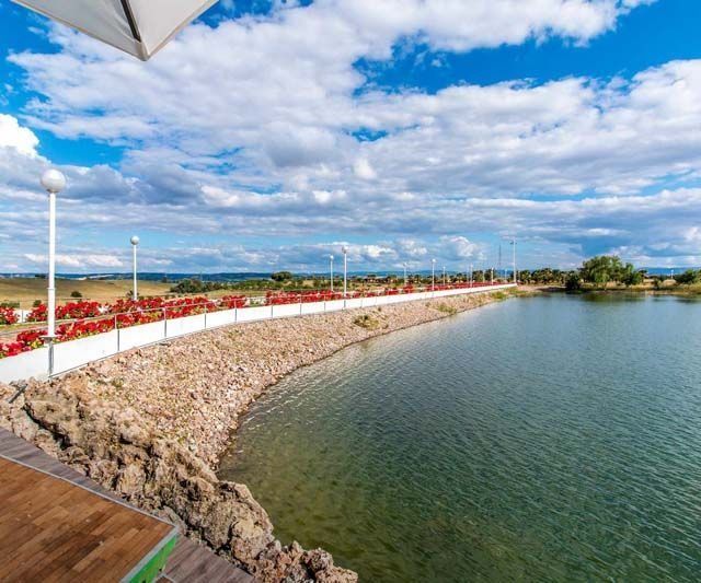 Un gran cuerpo de agua con una plataforma de madera en primer plano.
