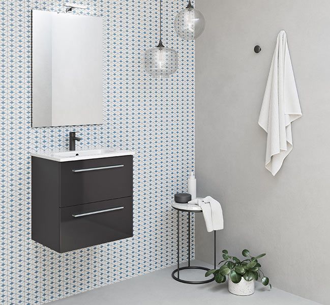 Un baño con lavabo, espejo y una planta.