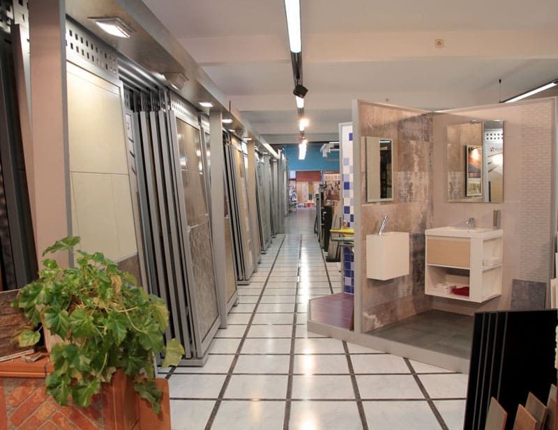 Una sala de exposición de baño con una planta en el medio.