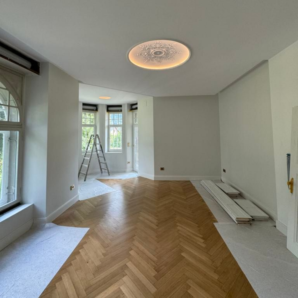 Travaux de plâtrerie, plafond avec création en staff, escabeau et matériaux de construction sur un parquet