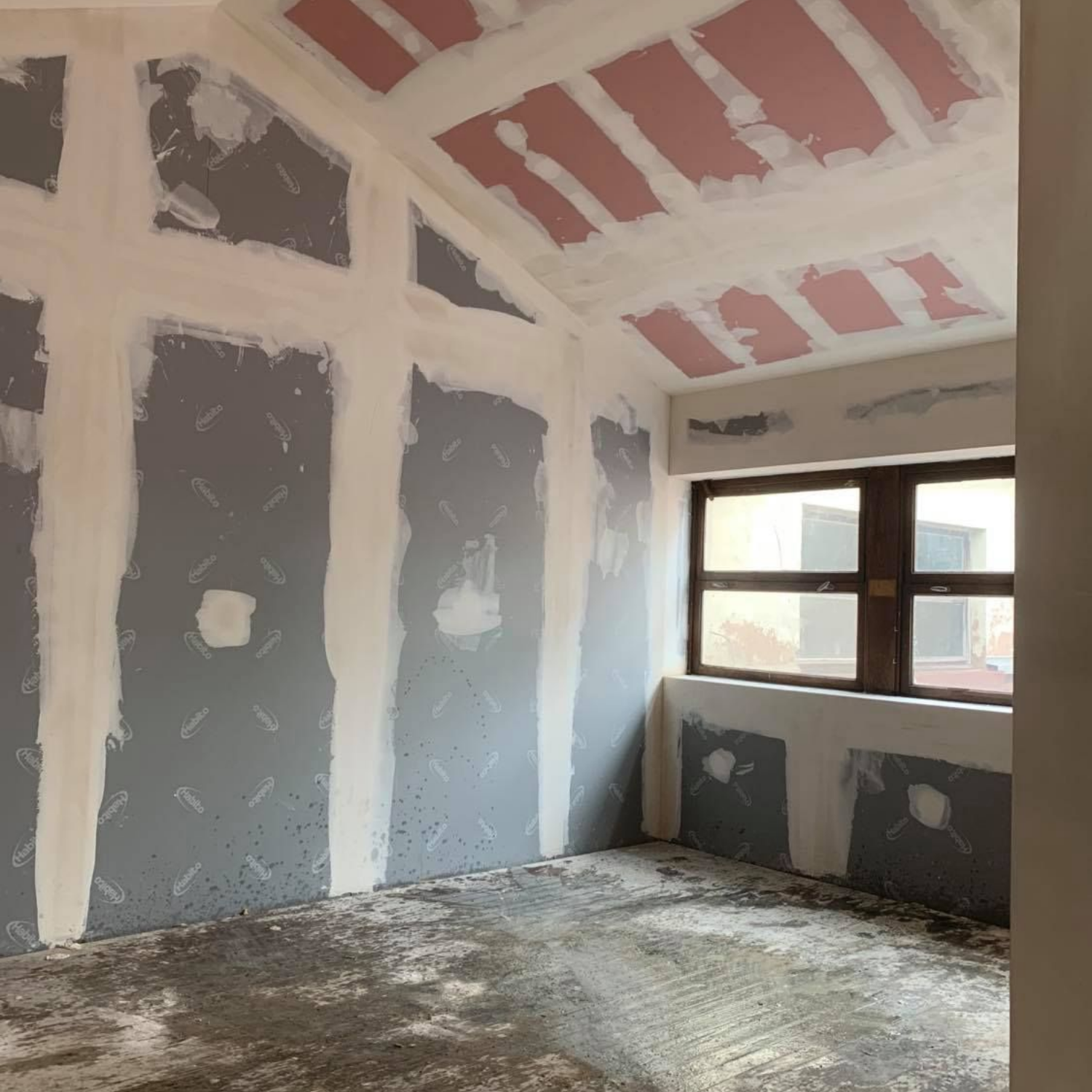 Travaux de plâtrerie en rénovation, pièce avec fenêtre