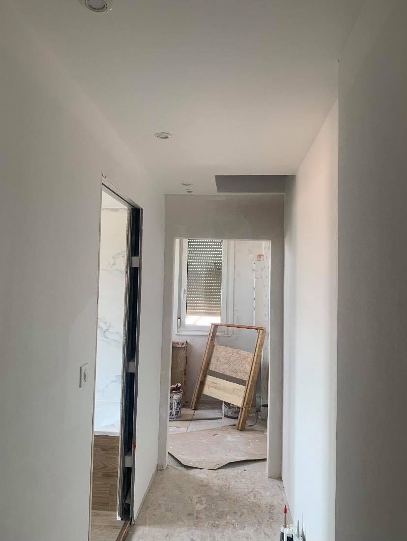 Travaux de pose de cloisons dans un couloir, chantier de rénovation