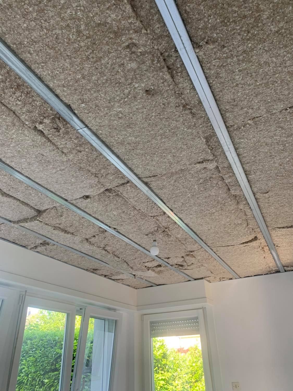 Isolation de faux plafond, laine de roche positionnée sur des rails