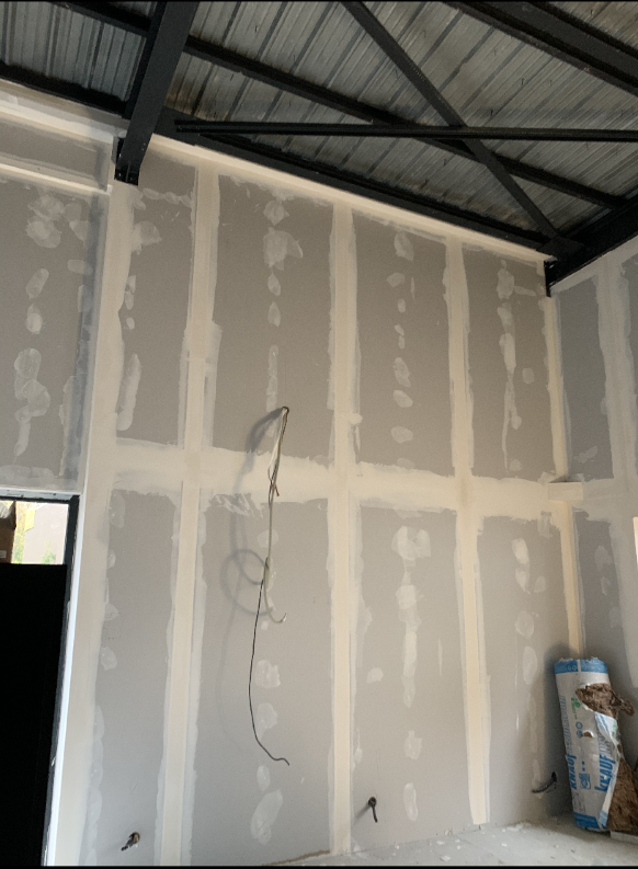 Cloison de doublage, fil électrique sortant du mur et isolant posé sur le sol