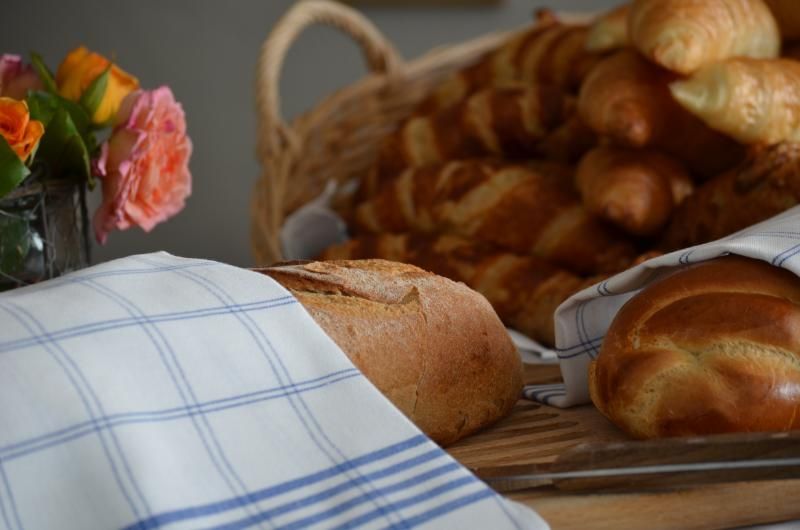 Ein Laib Brot ist in ein blau-weiss kariertes Handtuch eingewickelt. Foto vom Gmaandhuus Wilchingen