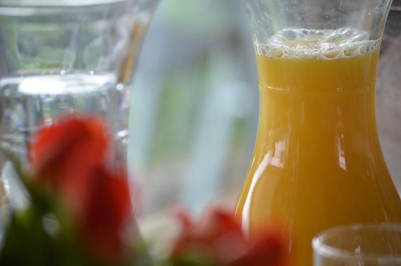Ein Krug Orangensaft steht neben einem Glas Wasser auf einem Tisch. Foto vom Gmaandhuus Wilchingen