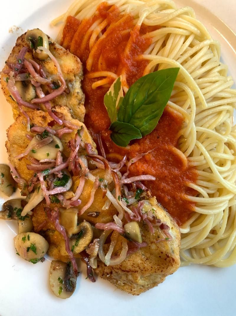 Ein weisser Teller mit Spaghetti, Hühnchen und Sosse. Foto vom Gmaandhuus Wilchingen