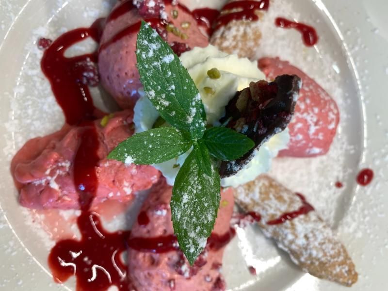 Eine Nahaufnahme eines Tellers mit Eiscreme und einem Minzblatt darauf. Foto vom Gmaandhuus Wilchingen