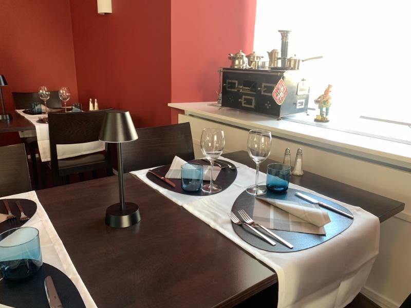 Ein Restauranttisch mit einer Lampe und Gläsern darauf. Foto vom Gmaandhuus Wilchingen