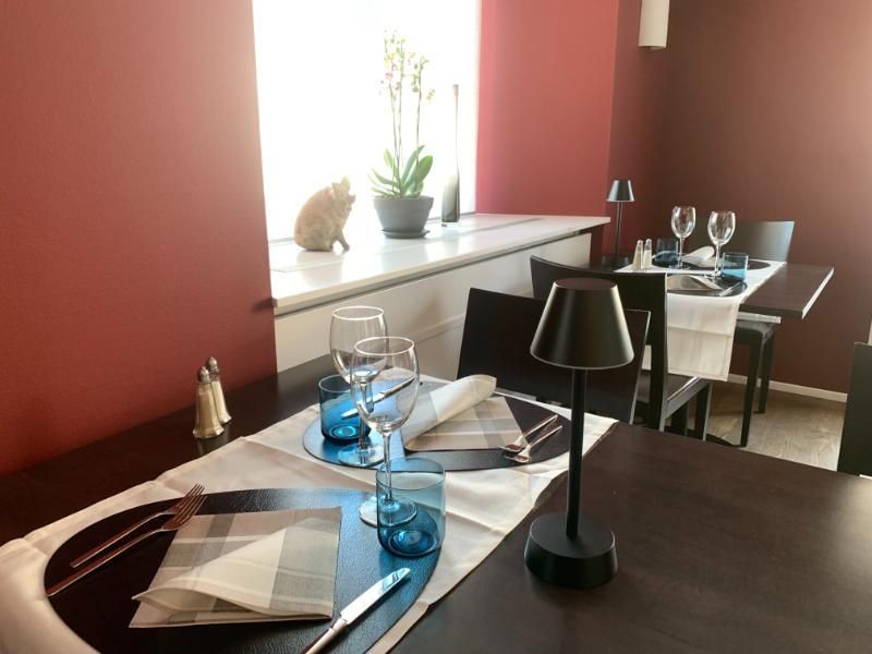 Ein Restaurantsaal mit Tischen und Stühlen und einer Lampe auf dem Tisch. Foto vom Gmaandhuus Wilchingen