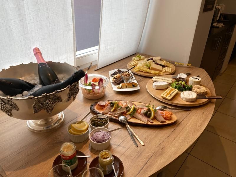 Ein Buffettisch mit Tellern voller Essen und einer Flasche Champagner. Foto vom Gmaandhuus Wilchingen